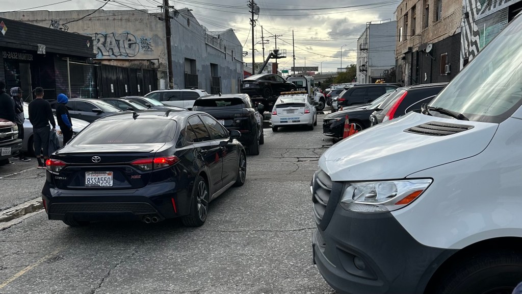 A congested urban street showcasing car drivers cruising for limited on-street parking