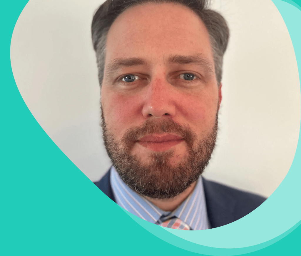 headshot of president Tony Jordan. He is wearing a suit with a pink stripped coloured tie.